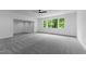 Spacious bedroom featuring a ceiling fan, gray carpet, and large windows with natural light at 310 Hidden Lake Dr, Youngsville, NC 27596