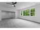 Large bedroom featuring gray carpet, a ceiling fan, and a large window offering ample natural light at 310 Hidden Lake Dr, Youngsville, NC 27596