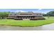 Lakeside view of a charming home with a shingled roof and lush green lawn at 310 Hidden Lake Dr, Youngsville, NC 27596