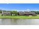 Lakeside view of a charming home with a shingled roof, gazebo and lush lawn at 310 Hidden Lake Dr, Youngsville, NC 27596