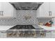 Modern kitchen features a stainless steel range with a decorative tile backsplash and a pot filler faucet at 310 Hidden Lake Dr, Youngsville, NC 27596