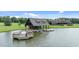 Beautiful lake view featuring boathouse, large deck, and the main house at 310 Hidden Lake Dr, Youngsville, NC 27596