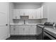 Well-organized laundry room with white cabinets, black hardware, and a modern washer and dryer at 310 Hidden Lake Dr, Youngsville, NC 27596
