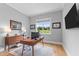 Well-lit home office with modern desk, wood floors, area rug, and window with backyard views at 310 Hidden Lake Dr, Youngsville, NC 27596