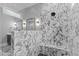 Luxurious shower with a window and marble tile surround and black hexagon shower floor at 310 Hidden Lake Dr, Youngsville, NC 27596