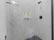 Contemporary shower featuring marble tile, black hardware, a shower niche, and natural light at 310 Hidden Lake Dr, Youngsville, NC 27596