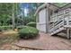 A spacious backyard with white stairs with brick elements, greenery, and a lush natural setting at 3205 Dell Dr, Raleigh, NC 27609