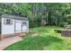 A lush, spacious backyard features a shed, a seating area, and a well-maintained lawn, perfect for outdoor activities at 3205 Dell Dr, Raleigh, NC 27609