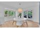 Sunlit dining room featuring a modern chandelier and a view to the outdoor patio at 3205 Dell Dr, Raleigh, NC 27609