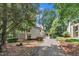 Exterior view of house with long driveway and mature trees providing ample shade at 3205 Dell Dr, Raleigh, NC 27609