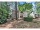 An exterior side view shows the home's architecture, landscaping, and an elevated treehouse at 3205 Dell Dr, Raleigh, NC 27609