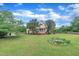 Expansive backyard with a well-maintained lawn, mature trees, storage shed, and inviting fire pit area for outdoor living at 35 Stratton Ct, Youngsville, NC 27596
