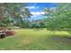 Large backyard featuring a spacious lawn, wooden fence, and a charming fire pit area surrounded by mature trees at 35 Stratton Ct, Youngsville, NC 27596