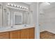 Bathroom featuring double sinks, wood cabinets, large mirror, and vanity lighting at 35 Stratton Ct, Youngsville, NC 27596