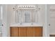 Bathroom featuring double sinks, wood cabinets, large mirror, and vanity lighting at 35 Stratton Ct, Youngsville, NC 27596