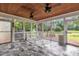 Enclosed back porch featuring marble-patterned tile floors and two ceiling fans at 35 Stratton Ct, Youngsville, NC 27596