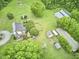 Lush aerial view of property showcasing landscaping, outbuildings, main house, and mature trees at 3679 Oak Lawn Farm Rd, Oxford, NC 27565