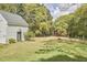 An outbuilding surrounded by a pasture where sheep are grazing, a fence, and lush trees at 3679 Oak Lawn Farm Rd, Oxford, NC 27565