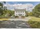 A beautiful colonial style house with mature landscaping and a circular driveway at 3679 Oak Lawn Farm Rd, Oxford, NC 27565