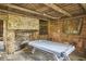 Game room with stone fireplace, air hockey table, and rustic wooden walls at 3679 Oak Lawn Farm Rd, Oxford, NC 27565