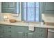 Close-up of the kitchen sink and counters featuring ample cabinetry and wood floors at 3679 Oak Lawn Farm Rd, Oxford, NC 27565