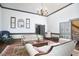 Large living room with vintage sofas, tall ceilings, and a decorative chandelier at 3679 Oak Lawn Farm Rd, Oxford, NC 27565