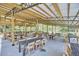 Interior view of the wooden pavilion area with wooden seating and tables at 3679 Oak Lawn Farm Rd, Oxford, NC 27565