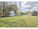 Expansive view of the property featuring green lawns, white outbuildings, and mature trees at 3679 Oak Lawn Farm Rd, Oxford, NC 27565
