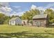 View of yard and buildings with various wooden structures and small trees with metal roofs at 3679 Oak Lawn Farm Rd, Oxford, NC 27565
