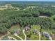 Scenic aerial view showcasing houses nestled among green trees with a tranquil pond, providing a serene neighborhood setting at 3728 Marwick Ct, Wendell, NC 27591