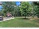Large, well-manicured backyard with mature trees, a patio set, and an outbuilding at 3728 Marwick Ct, Wendell, NC 27591
