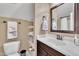 Bathroom with a toilet, a marble countertop sink with a dark wood cabinet, and convenient shelving at 3728 Marwick Ct, Wendell, NC 27591