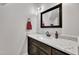 Bathroom featuring dark wood cabinets, a white quartz countertop, modern fixtures, and a framed mirror at 3728 Marwick Ct, Wendell, NC 27591