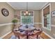 Cozy dining area featuring hardwood floors, a round table with leather chairs, and natural light from a window at 3728 Marwick Ct, Wendell, NC 27591