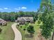 Charming brick home with a long driveway and well-manicured lawn featuring lush green trees and plants at 3728 Marwick Ct, Wendell, NC 27591