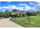 Beautifully landscaped front yard with a winding driveway, verdant lawn, and mature trees surrounding a stately home under a sunny sky at 3728 Marwick Ct, Wendell, NC 27591