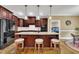 Kitchen island with granite countertop, pendant lighting, seating, and dark wood cabinets at 3728 Marwick Ct, Wendell, NC 27591