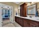 Bathroom featuring double sinks, mirrors, and dark cabinets; bedroom is nearby at 3728 Marwick Ct, Wendell, NC 27591