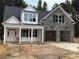Charming new two-story home boasts stone accents, black shutters, a two-car garage, and a covered front porch at 400 Abingdon Farms Dr, Selma, NC 27576