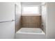 Bright bathroom featuring a tiled tub with a shower and a window for natural light at 400 W Rosemary St # 114, Chapel Hill, NC 27516
