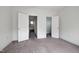 An empty bedroom features neutral walls, gray carpet, white trim, and two open doorways at 400 W Rosemary St # 114, Chapel Hill, NC 27516