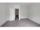 An empty bedroom features neutral walls, gray carpet, and white trim with an open doorway at 400 W Rosemary St # 114, Chapel Hill, NC 27516