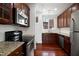 Well-lit kitchen with stainless steel appliances, granite countertops, and cherry wood cabinets at 400 W Rosemary St # 114, Chapel Hill, NC 27516