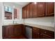 Galley kitchen featuring wood cabinetry, granite countertops, stainless steel appliances, and a bright window at 400 W Rosemary St # 114, Chapel Hill, NC 27516