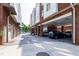 Exterior shot of a parking area under brick buildings with multiple parked cars and ample space at 400 W Rosemary St # 114, Chapel Hill, NC 27516