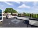 A roof deck with black metal railing offering views of nearby rooftops and lush green trees at 400 W Rosemary St # 114, Chapel Hill, NC 27516
