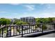 A rooftop view featuring a black metal railing, the cityscape, and vibrant green trees at 400 W Rosemary St # 114, Chapel Hill, NC 27516
