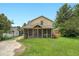 Home's backyard featuring expansive screened porch and lovely green grass, trees, and blue sky at 407 Hillcrest Ave, Burlington, NC 27215