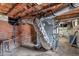 Unfinished basement featuring exposed ductwork, brick walls, and mechanical equipment at 407 Hillcrest Ave, Burlington, NC 27215