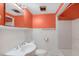 Compact bathroom with a white vanity, toilet, and shower/tub with orange accents at 407 Hillcrest Ave, Burlington, NC 27215